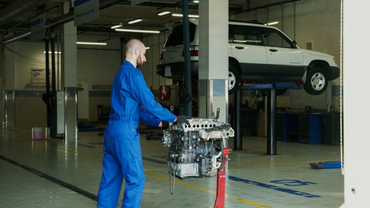 Mechanic in a service garage fixing an engine