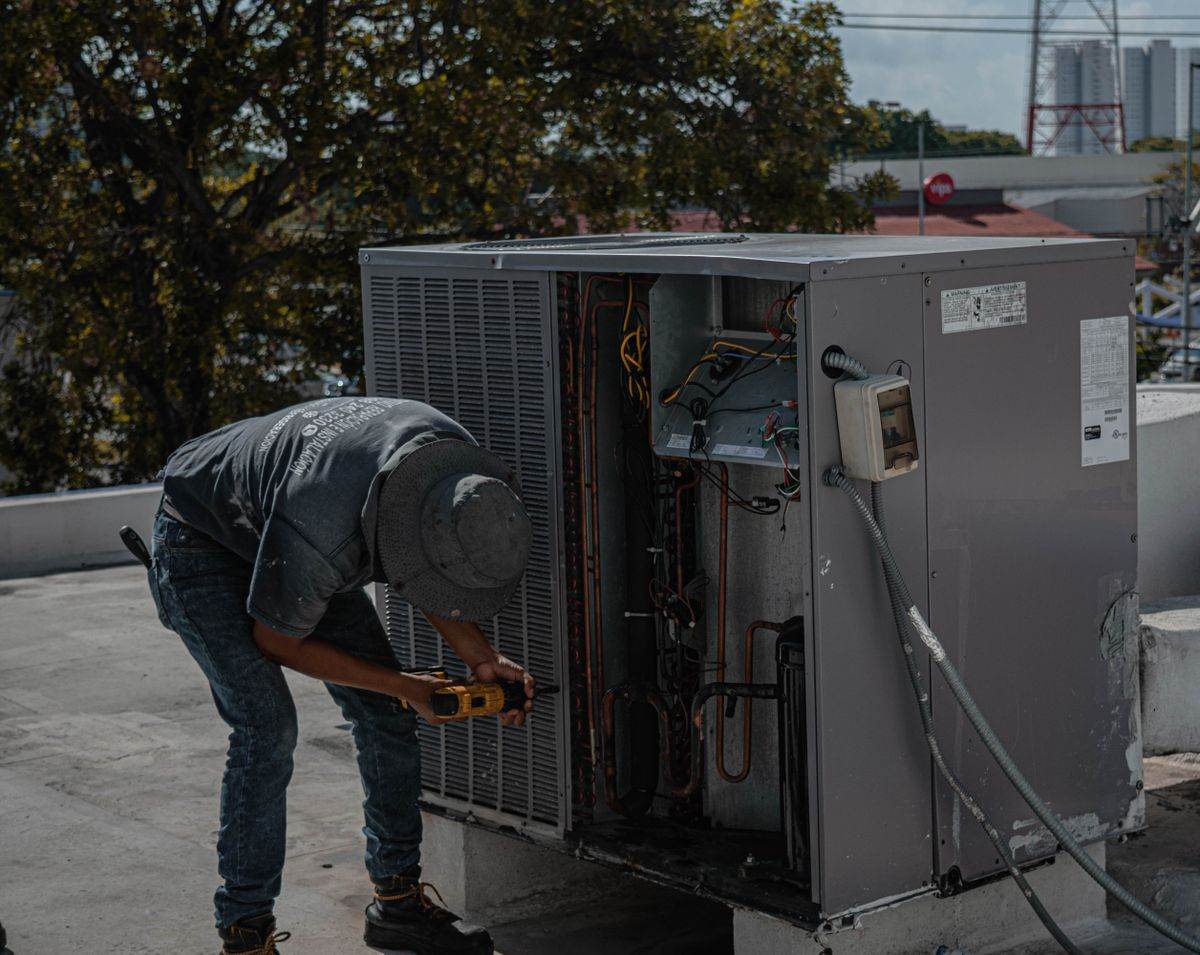 HVAC technician repairing a rooftop air-conditioning unit