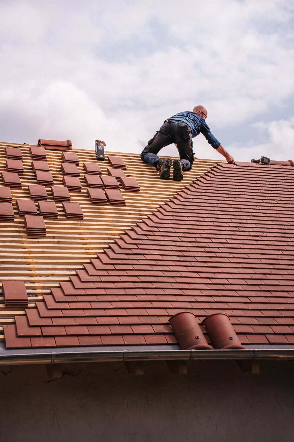 Roofer installing shingles on a new residential roof